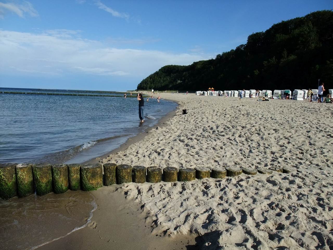 Eine Person steht an einem Sandstrand nahe der Ostsee.