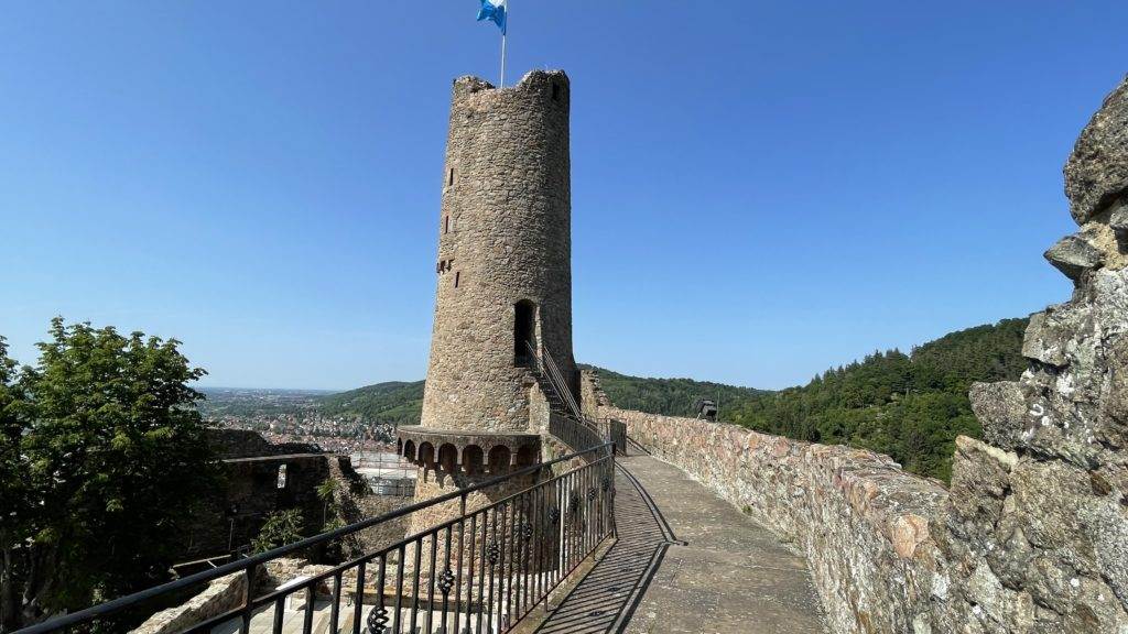 Ein Burgturm mit einer Fahne darauf.