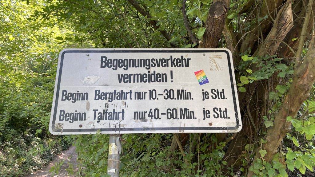 Ein Schild am Straßenrand mit einem Regenbogen darauf.