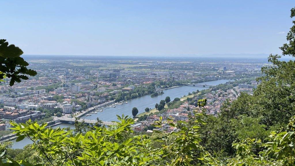 Heidelberg kommt in Sicht, Burgensteig. Ein Blick auf eine Stadt von einem Hügel mit Blick auf einen Fluss.