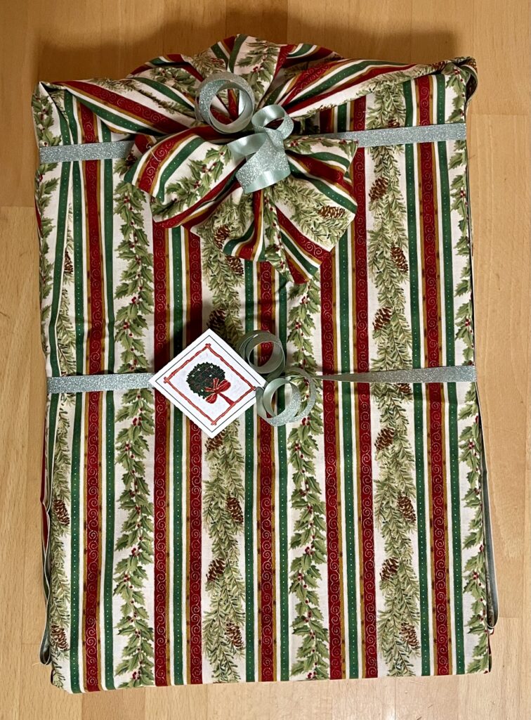 Ein Weihnachtsgeschenk, verpackt in einem roten, grünen und weißen Streifen.