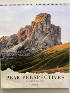Ein Wandkalender mit dem Titel "Peak Perspectives" für das Jahr 2026 zeigt auf dem Cover eine felsige Berglandschaft im warmen Sonnenlicht.