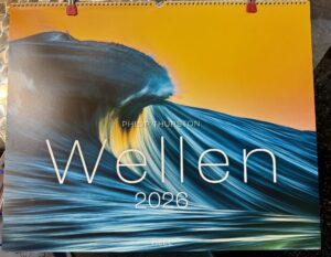 Der Wandkalender 2026 mit dem Titel "Wellen" von Philip Thurston zeigt auf dem Titelbild eine stilisierte Fotografie einer Welle vor einem orangefarbenen Himmel.