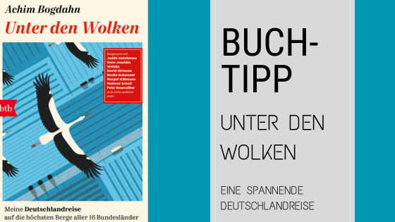 Buchumschlag von "Unter den Wolken" von Achim Bogdahn mit fliegenden Störchen vor blauem Himmel und Stromleitungen; Texttafel empfiehlt das Buch als Reisetipp für Deutschland.
